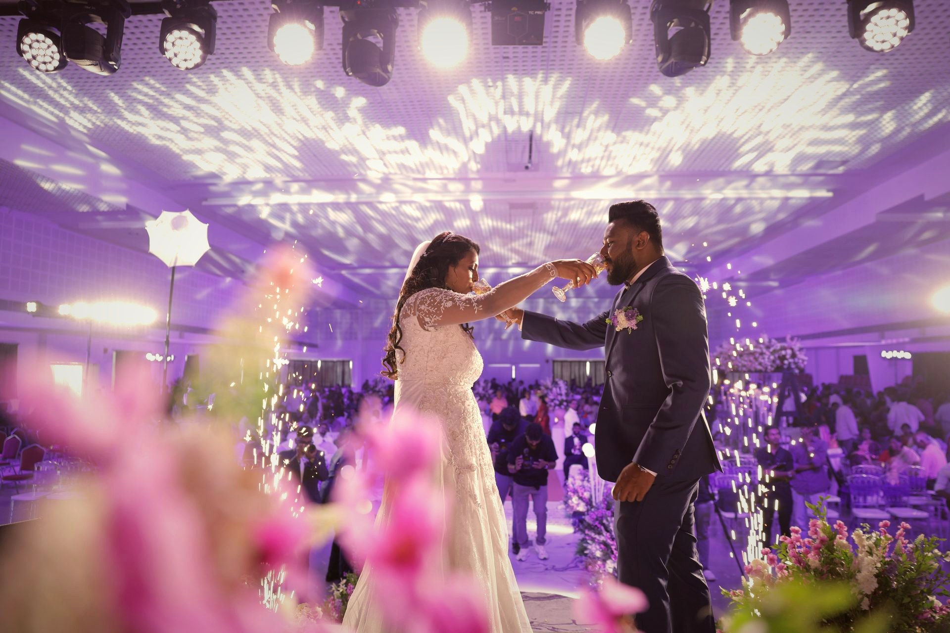 A toast mid first dance, sparklers behind them